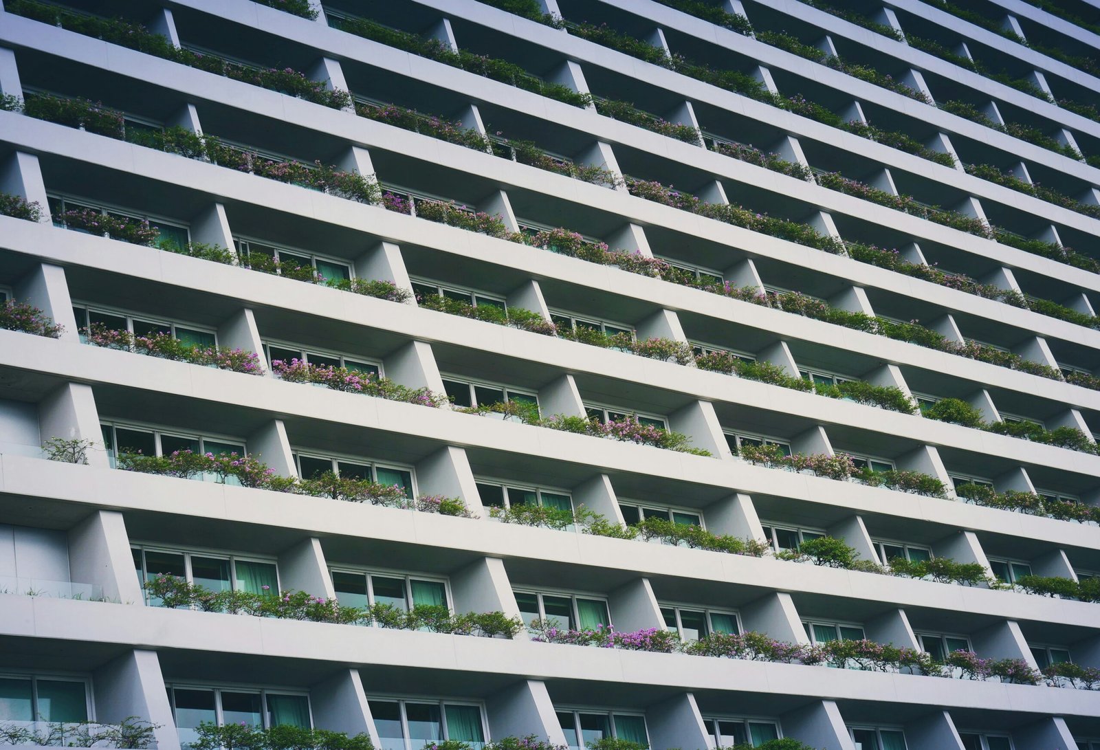 low-angle photography of white building with garden terrace